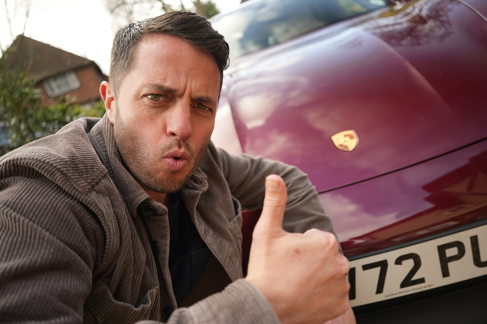 the sustainable dad posing next to the Porsche taycan cross tourism