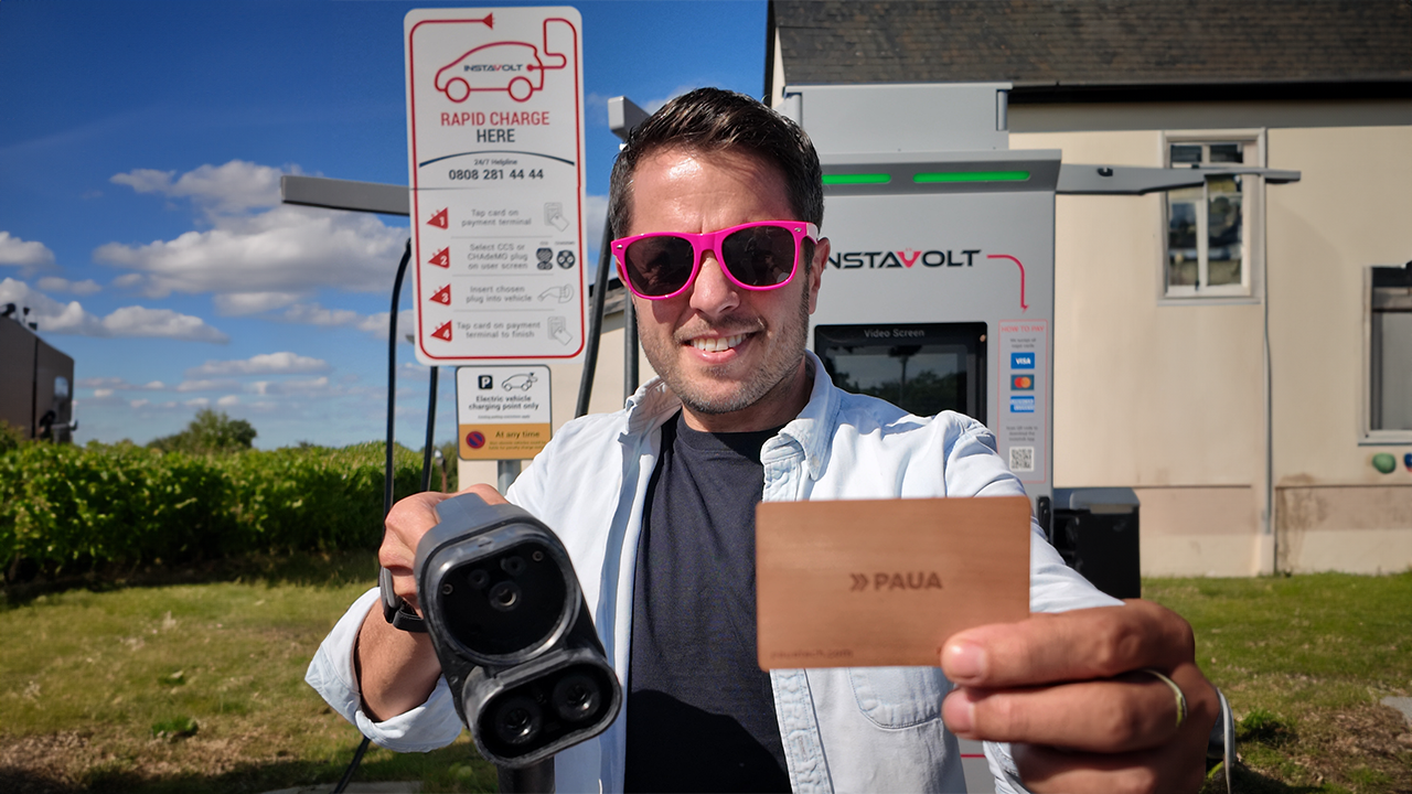 A man holding a Paua card showing people how to public charge